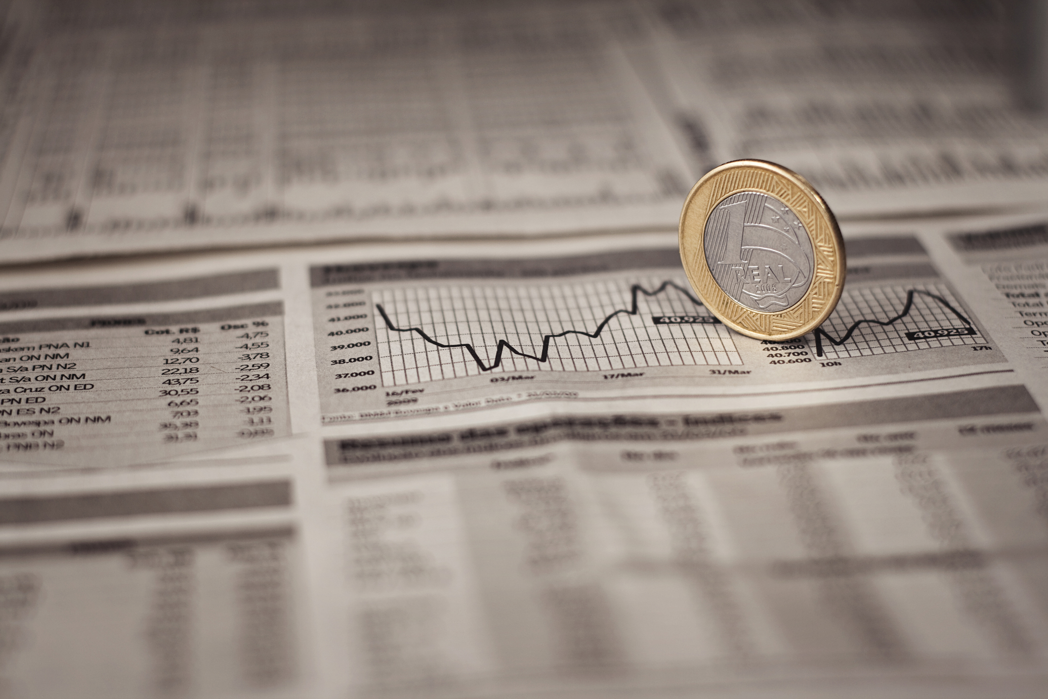 Brazilian Economy Real, Brazilian economy, with a 1 Real coin over a graphic in a newspaper. Newspaper with coin on top of the grA!fico.